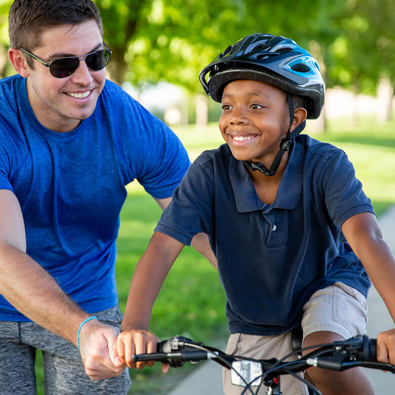 Male Big helping Little ride a bike