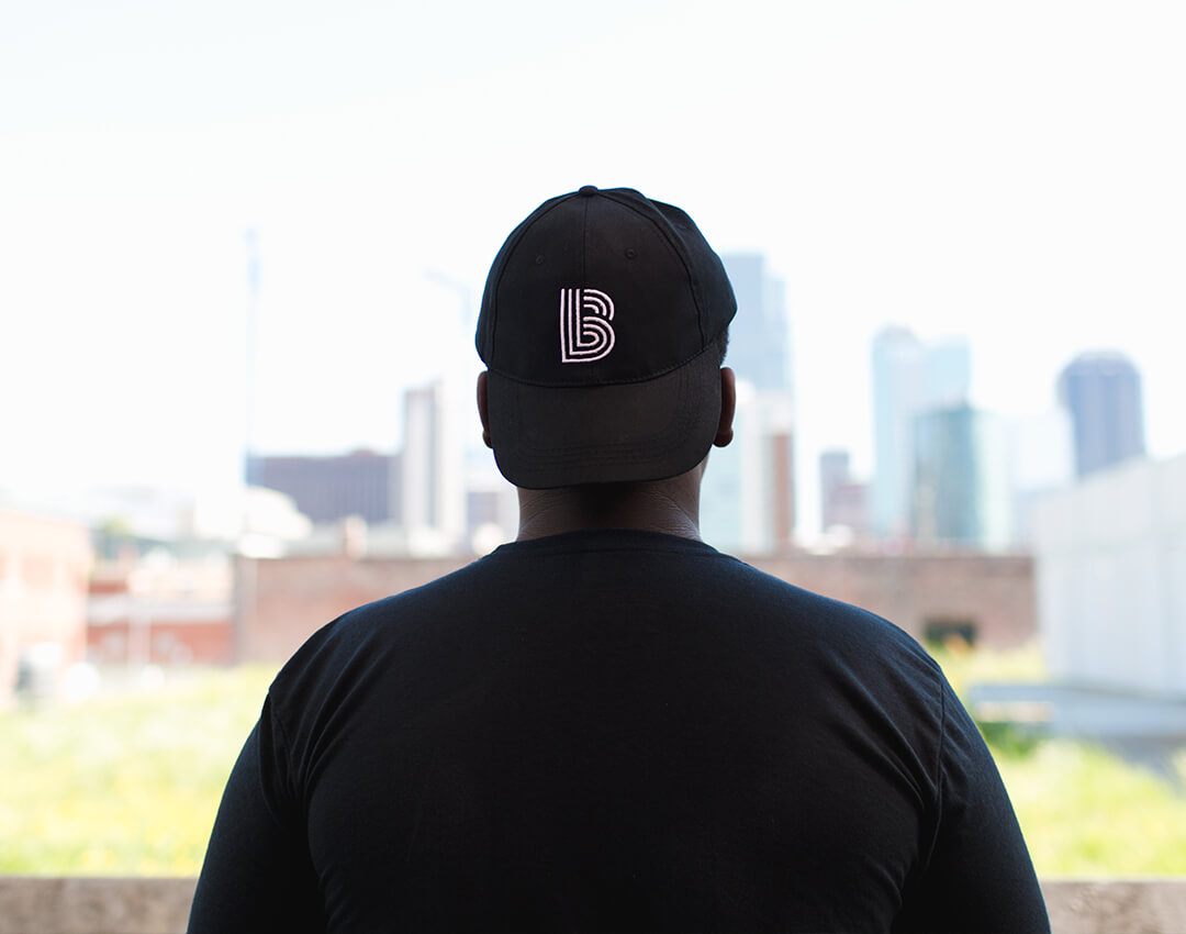 Child with BBBS hat looking at a downtown skyline